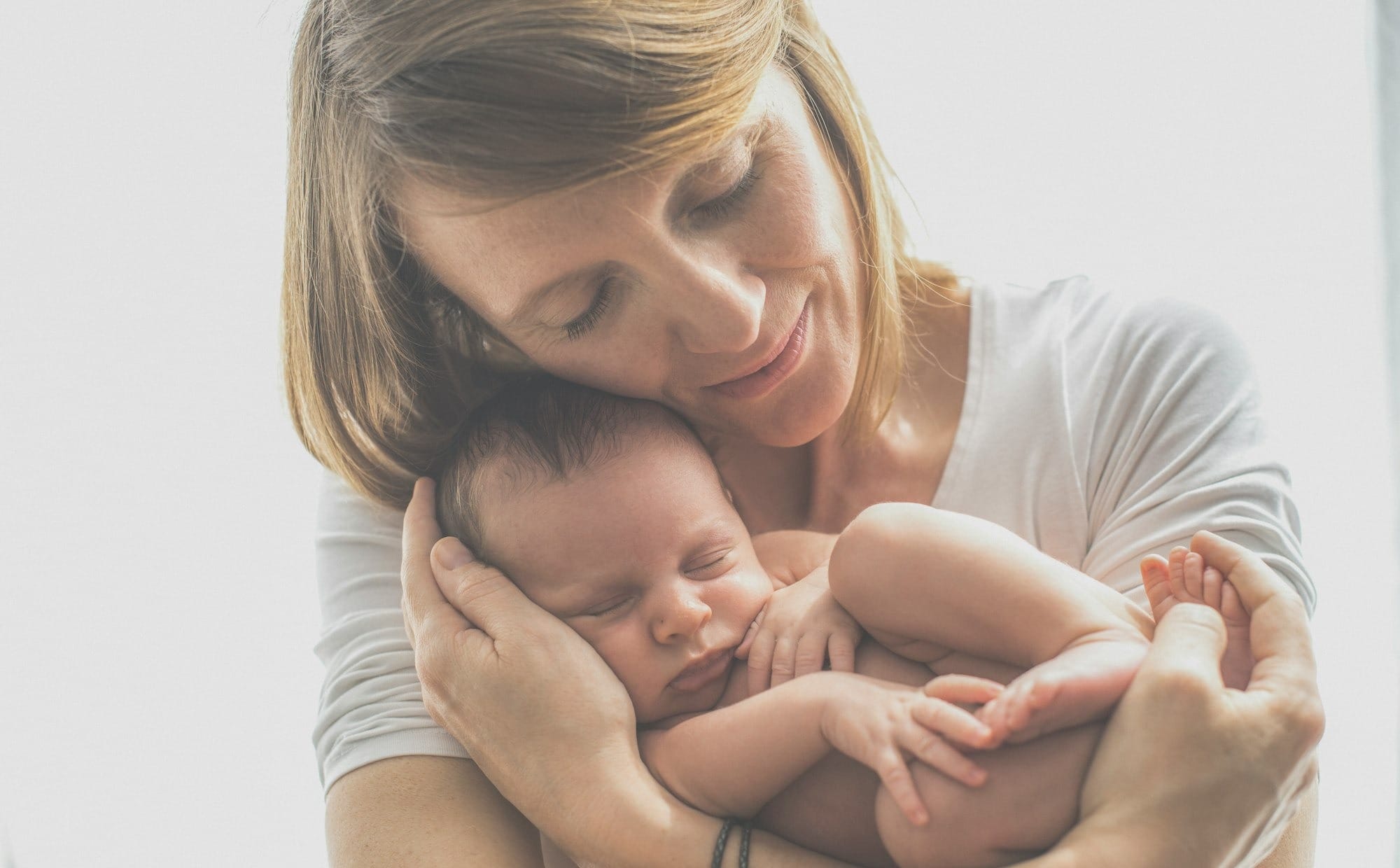 woman in white crew neck t-shirt carrying baby