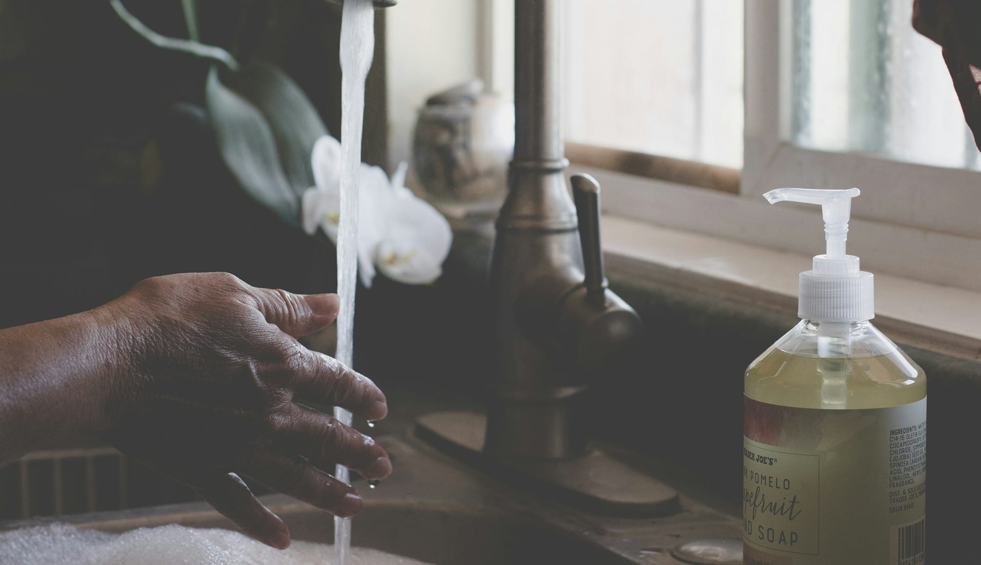 person holding white plastic pump bottle