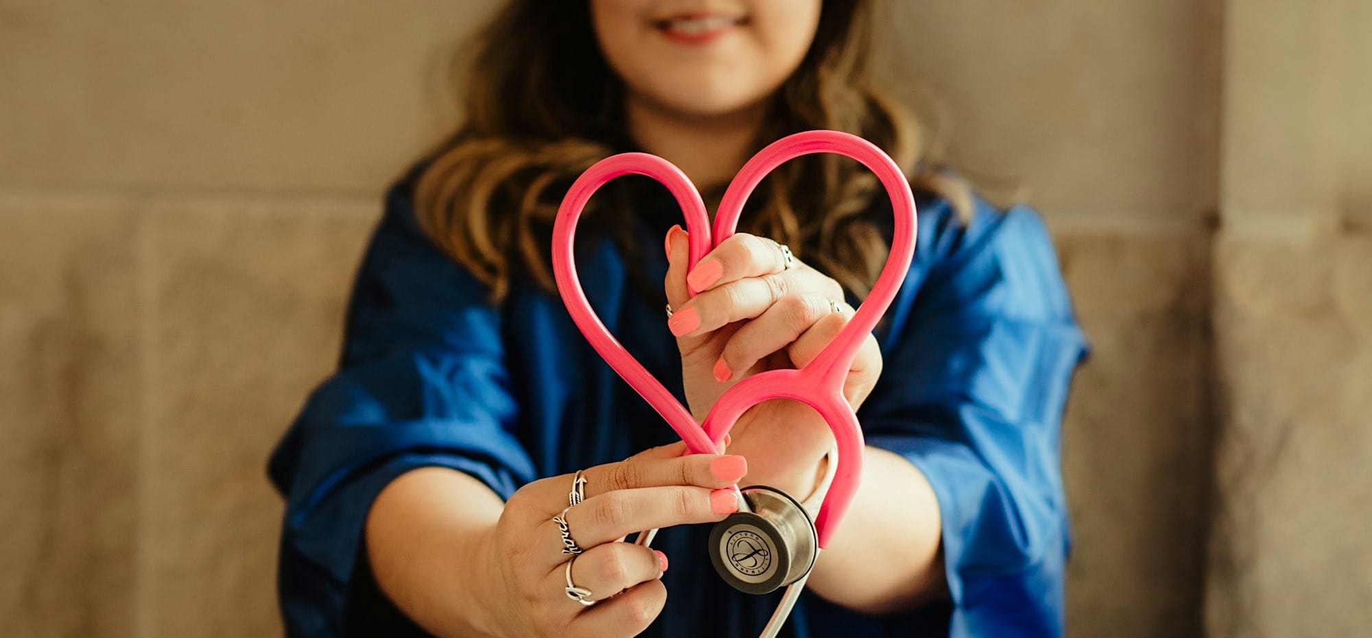 girl in blue jacket holding red and silver ring