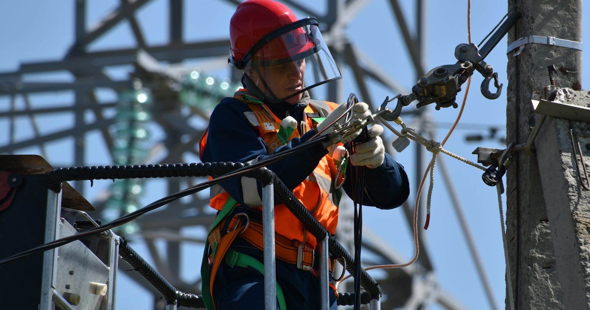 shallow focus photo of man fixing steel cable