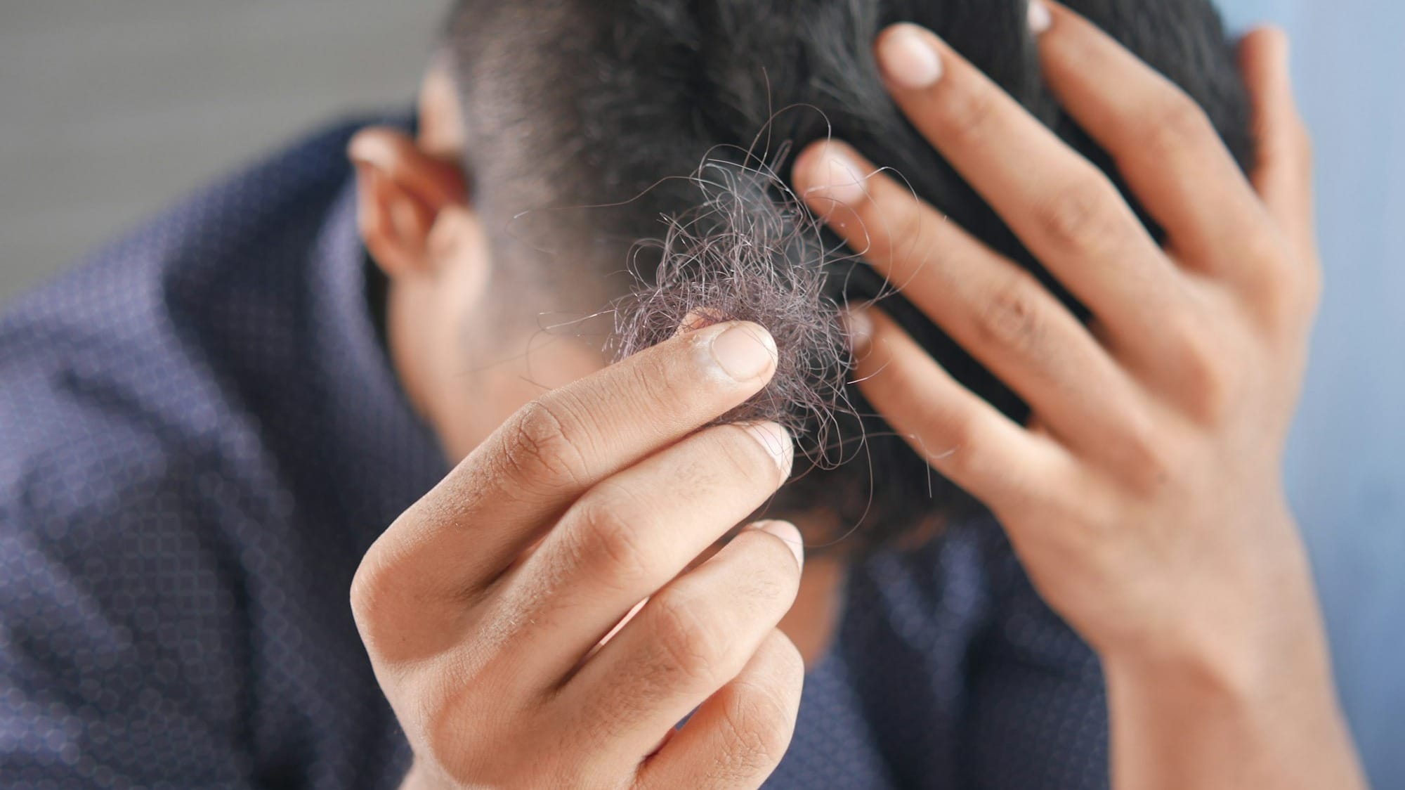 a man is combing his hair with his hands