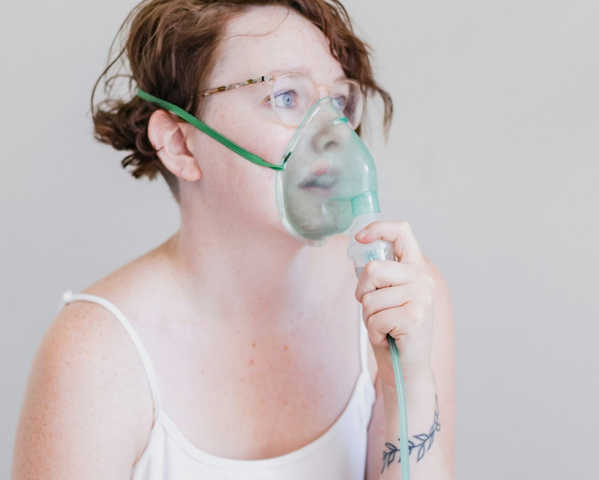 a woman sitting on a bed with a blow dryer in her mouth