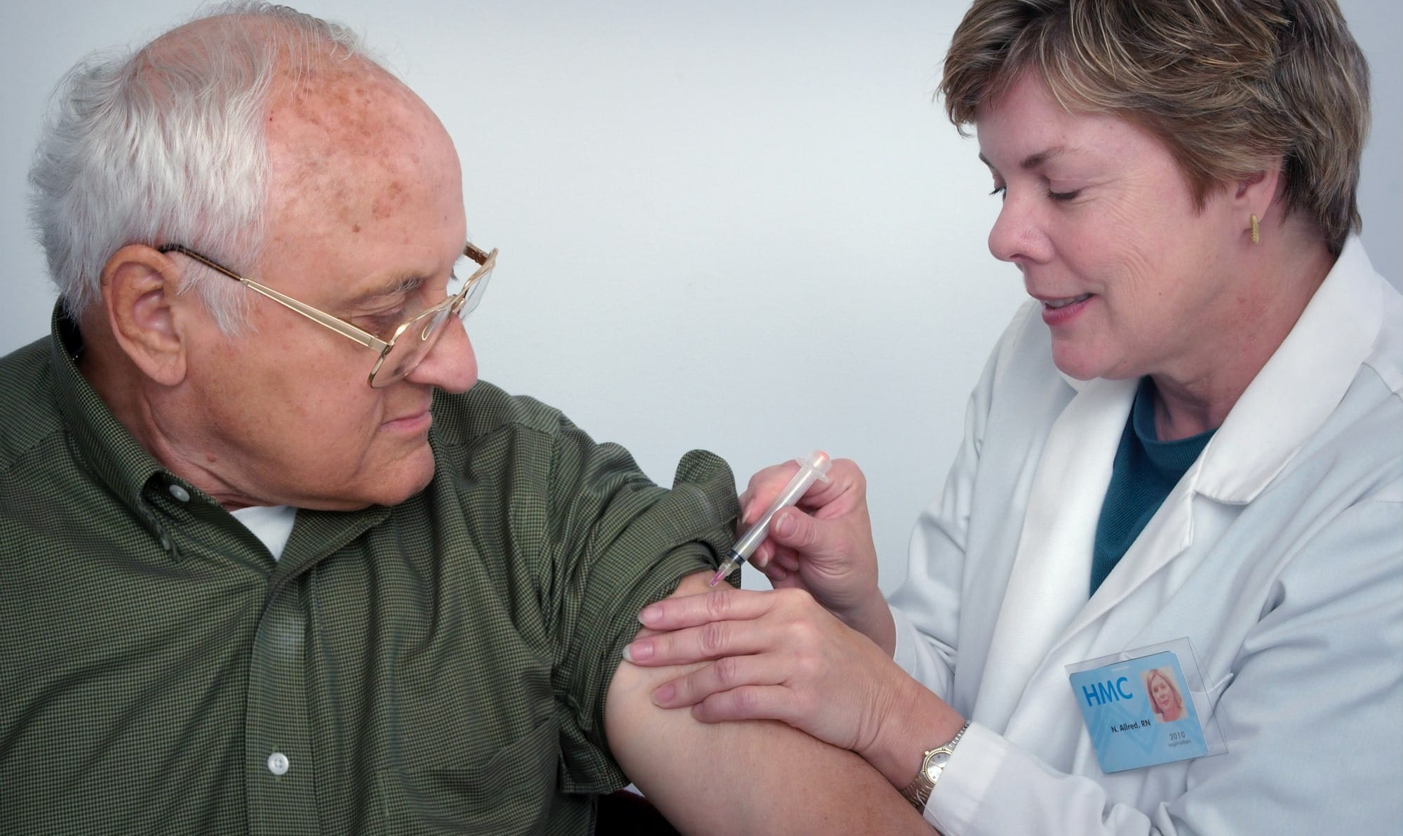 woman injecting syringe on mans arm